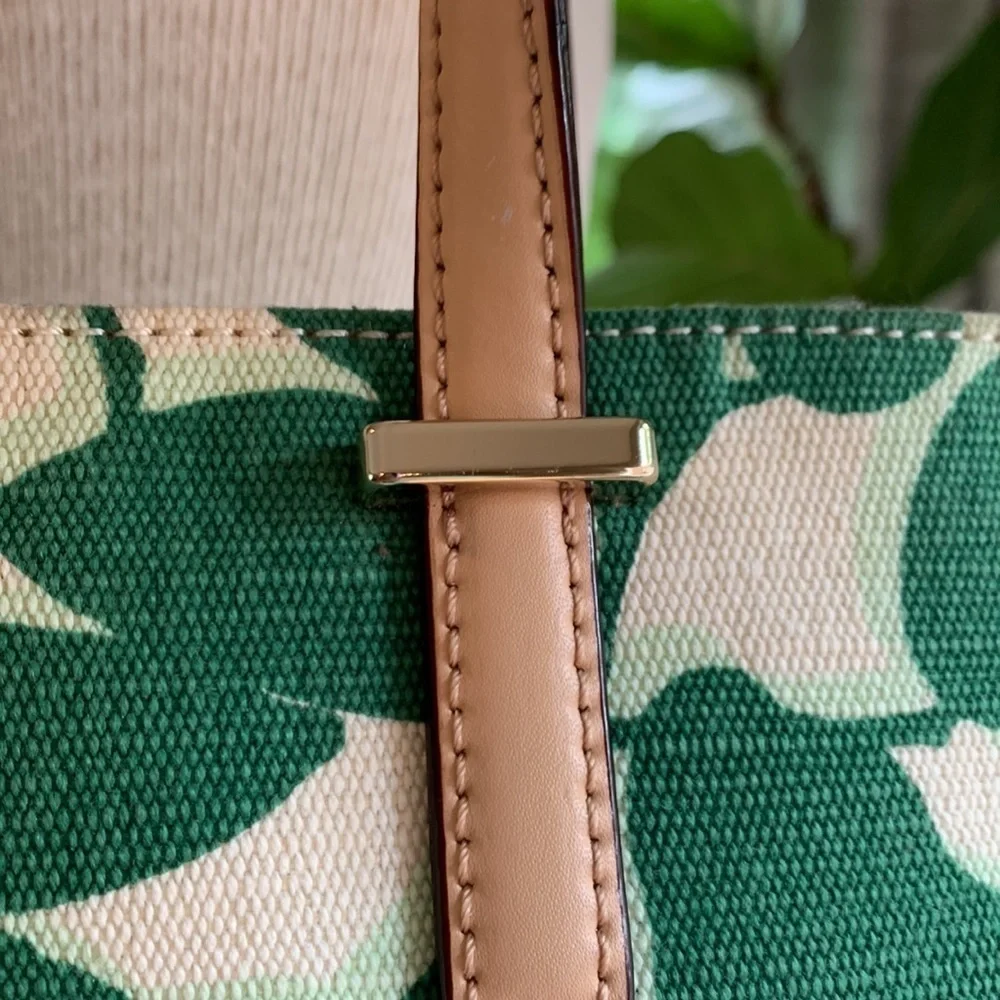 Kate Spade cream colored cloth tote with green leaf pattern.